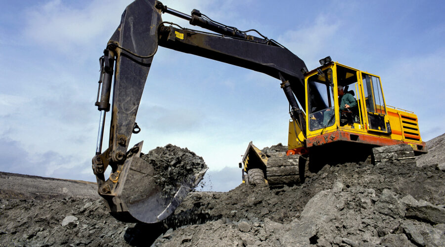 Mechanical excavator working in a quarry moving earth – United Kingdom.